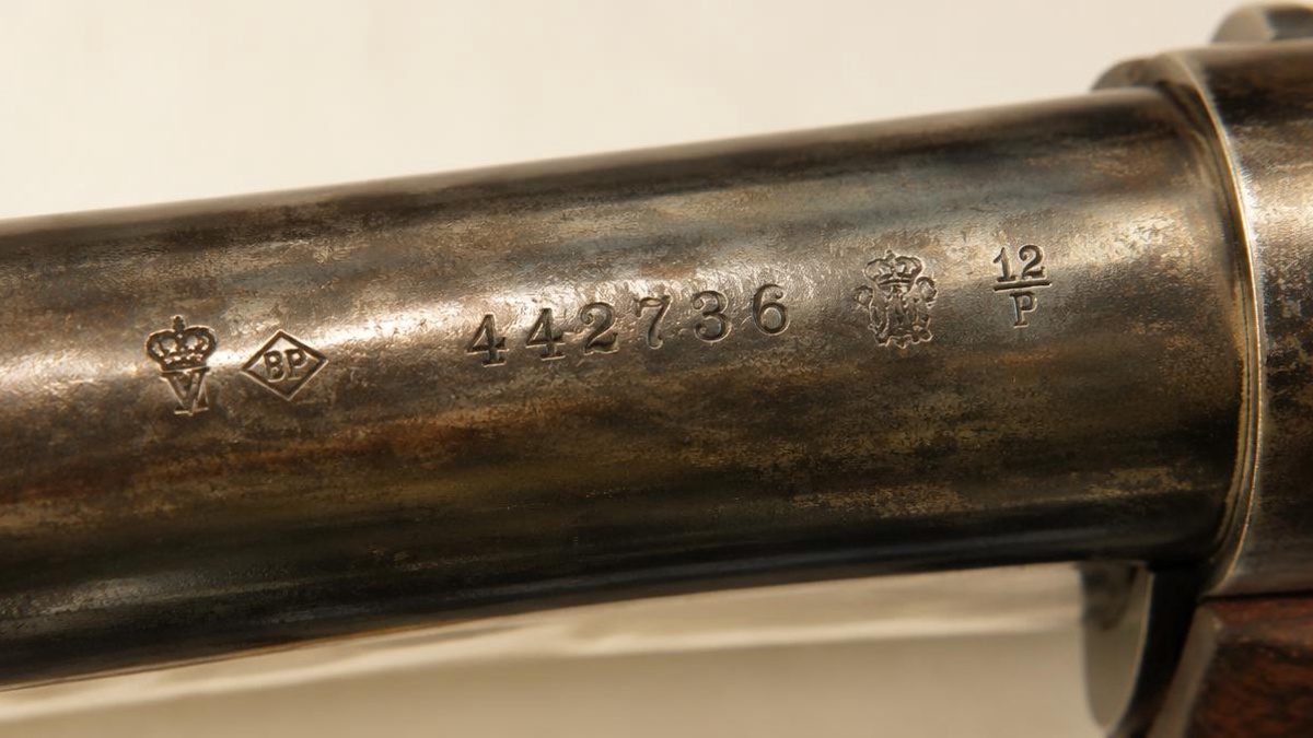 Close-up of proof marks and serial numbers on an antique gun barrel